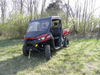 Front three-quarter view of a red Can-Am Defender with the 3 Star vinyl windshield and black top