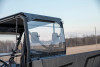 Kolpin rear window installed on a grey Can-Am Defender, seen from the cargo bed with the seats visible through the glass