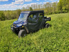 Blue Polaris Ranger with a 3 Star soft top and doors in tall grass, front three-quarter view