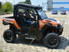 Passenger side view of a four-seat orange Polaris General 1000 with the Hard Cabs full enclosure and doors
