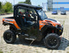 Hard Cabs hard cab enclosure on an orange Polaris General 1000, glass doors and windows, side view on a paved lot