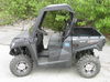 Side view of a black Kymco UXV 700 with the 3 Star black vinyl top and clear vinyl windshield installed