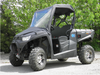 Driver side front view of a black Kymco UXV 700 with the 3 Star vinyl windshield and top on a gravel lot
