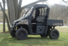 Side view of a camo Polaris Ranger with the 3 Star black vinyl top and clear windshield installed under a tree