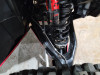 Close-up of the Trail Armor A-arm guard from above the Polaris RZR Pro R front shock, black plate with red trim