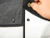 Close-up of a hand lifting the hook-and-loop flap and snap that secure the SuperATV soft door to the lower door