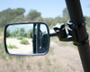 ATV-Tek Clearview side view mirror clamped to a UTV roll cage tube, reflecting a dirt trail and brush