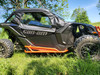 3 Star full cab enclosure on a gray Can-Am Maverick X3 with orange rock sliders, side view in tall grass