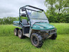 Front three-quarter view of a green six-wheel Polaris Ranger in a field with the 3 Star two-piece windshield