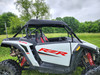 Driver side view of the white 2024-2025 Polaris RZR XP 1000 with the 3 Star canvas top installed by trees