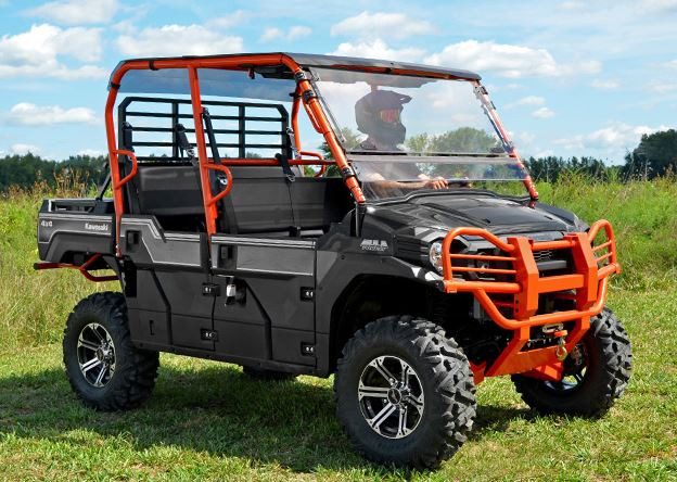 Front three-quarter view of a black Kawasaki Mule Pro-FXT with the SuperATV flip-out windshield closed in a field
