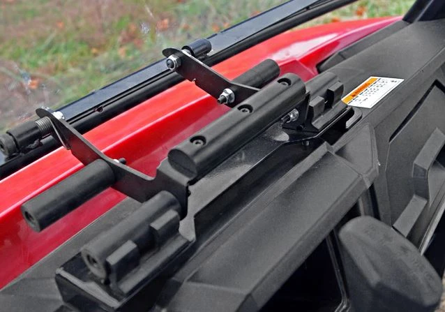 Close-up of the SuperATV flip-out windshield lower latch brackets on the red hood of a Polaris Ranger 570 Mid-Size