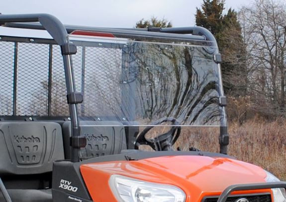 SuperATV full windshield installed on an orange Kubota RTV X-900, front three-quarter view in a field