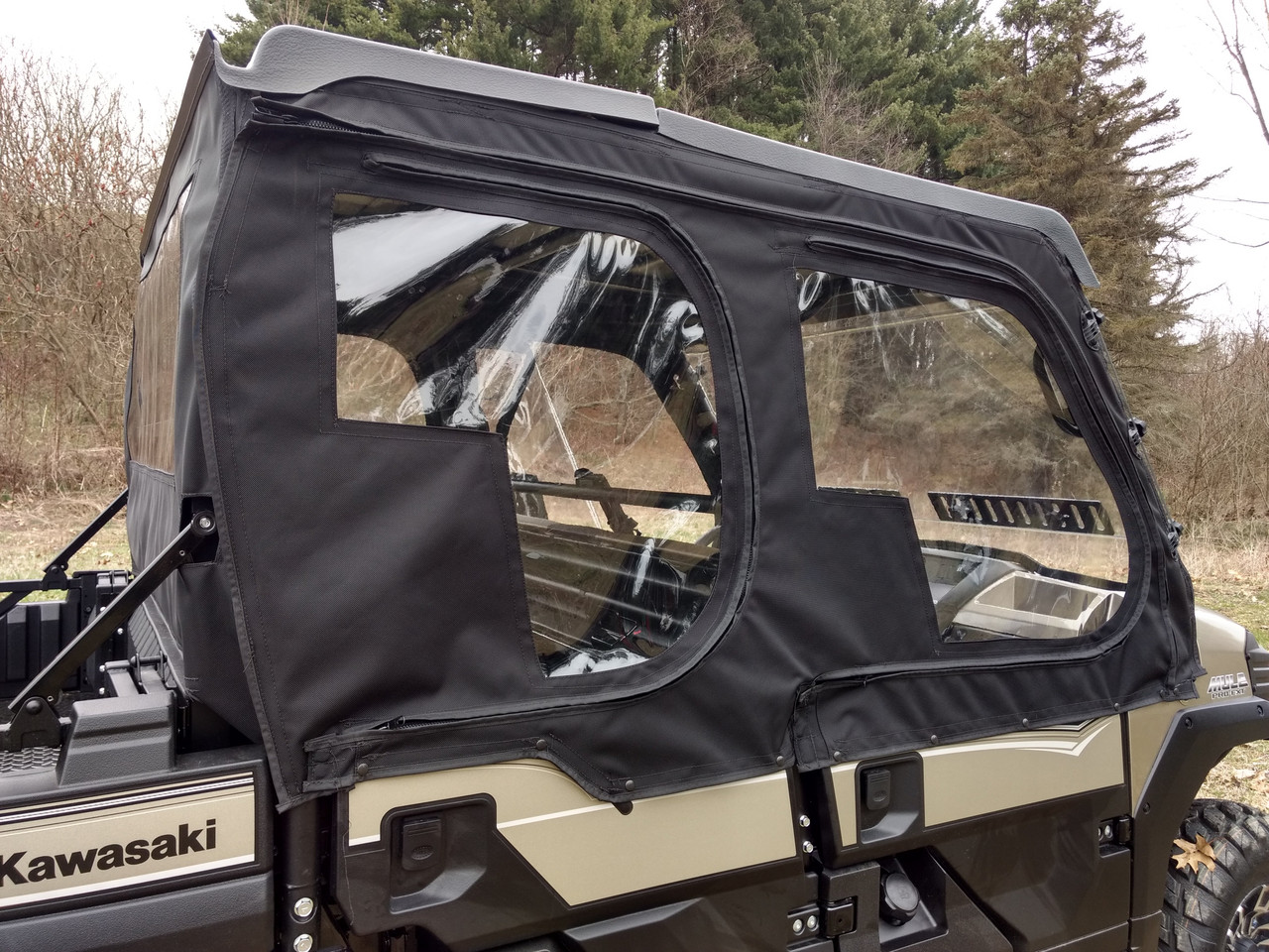Side X Side upper doors kit with clear windows on a tan Kawasaki Mule Pro FXT, close driver side view