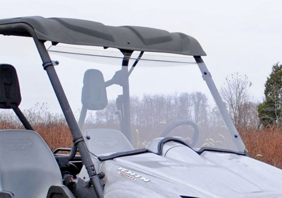 SuperATV scratch resistant full windshield installed on a silver Yamaha Rhino with roof, close front three-quarter view