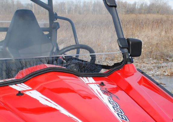 Side view of the SuperATV full windshield and cage clamp on the red CFMoto ZForce 800 with bare trees behind