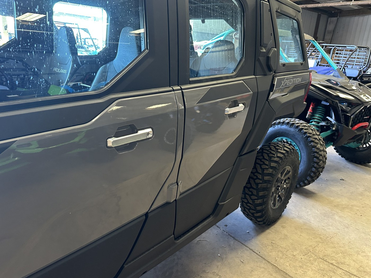 Low angle of a gray Polaris Xpedition with Dirty Teeth Racing billet exterior door handles on both doors
