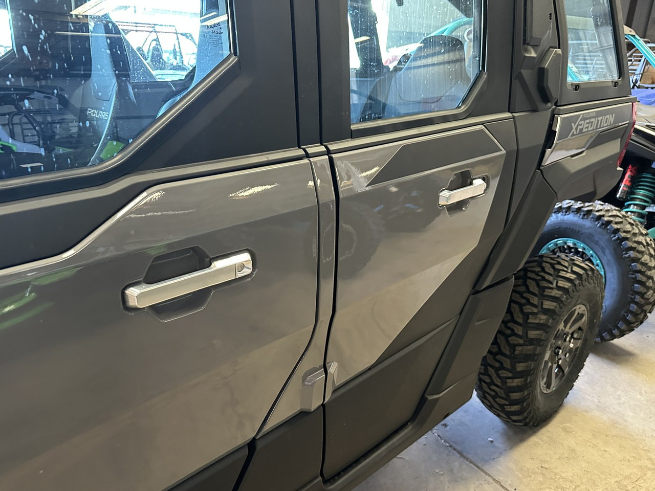 Front door of a gray Polaris Xpedition showing the Dirty Teeth Racing billet exterior door handle