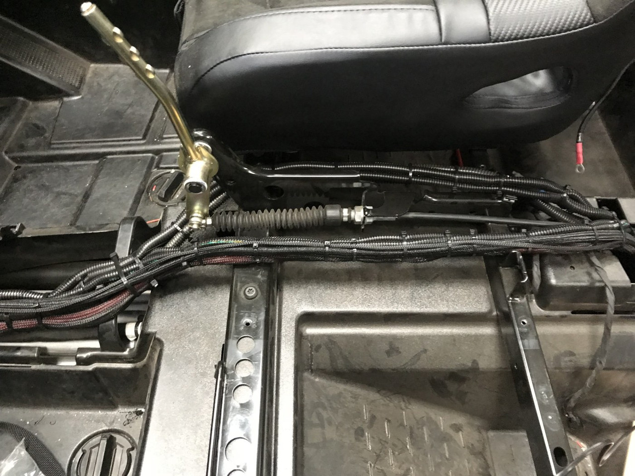 Dirty Teeth Racing busbar kit wiring routed in loom under the seat frame of a Polaris 4-seat side-by-side