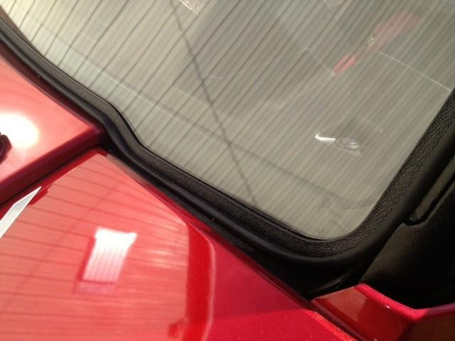 Close-up of the Extreme Metal Products windshield rubber seal running along the red Polaris Ranger hood