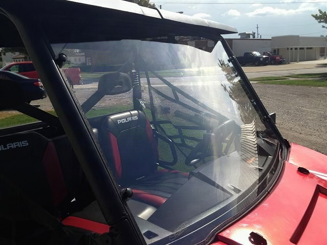 Extreme Metal Products full windshield installed on a red Polaris Ranger, side three-quarter view of the cab