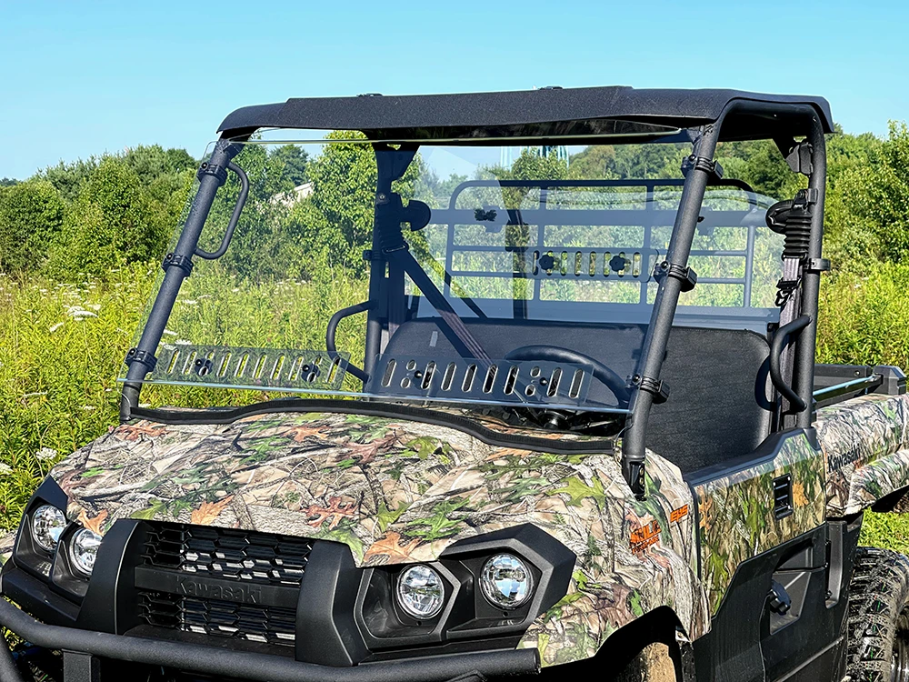 Spike windshield for Kawasaki Mule Pro-MX: vented windshield on a camo UTV, front view in a field