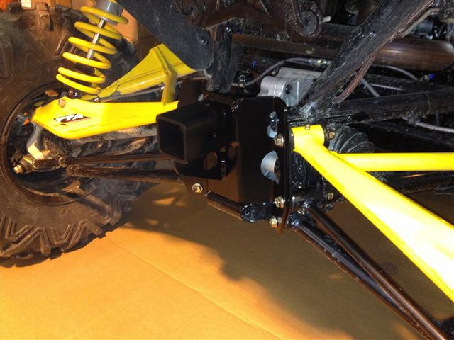 Extreme Metal Products high clearance rear hitch bolted under a Can-Am Maverick with yellow suspension arms