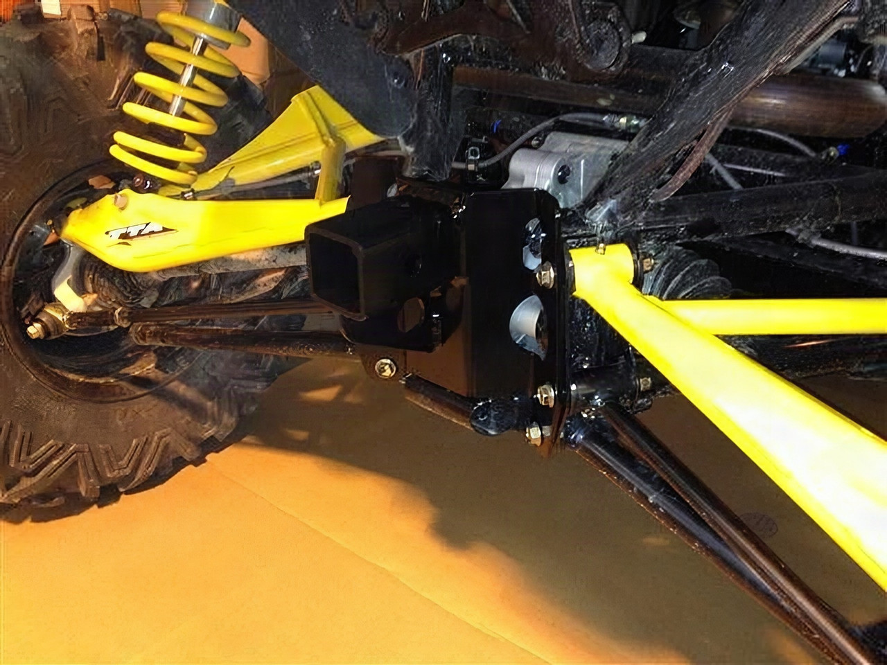 Extreme Metal Products high clearance rear hitch bolted under a Can-Am Maverick with yellow suspension arms