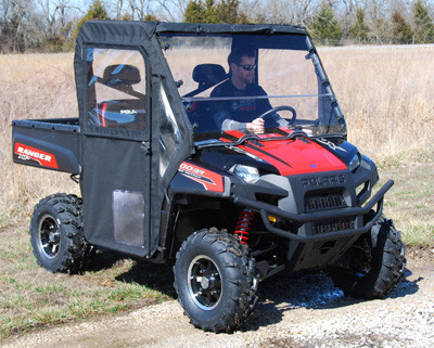 Front three-quarter view of the red Polaris Ranger 800 with Seizmik framed doors closed and driver in cab on a gravel trail