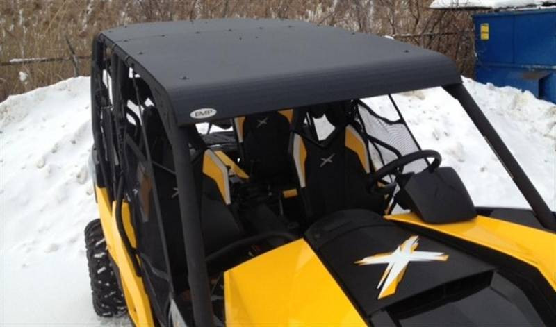 Side view of the yellow Can-Am Maverick Max with the Extreme Metal Products aluminum top beside a snow bank
