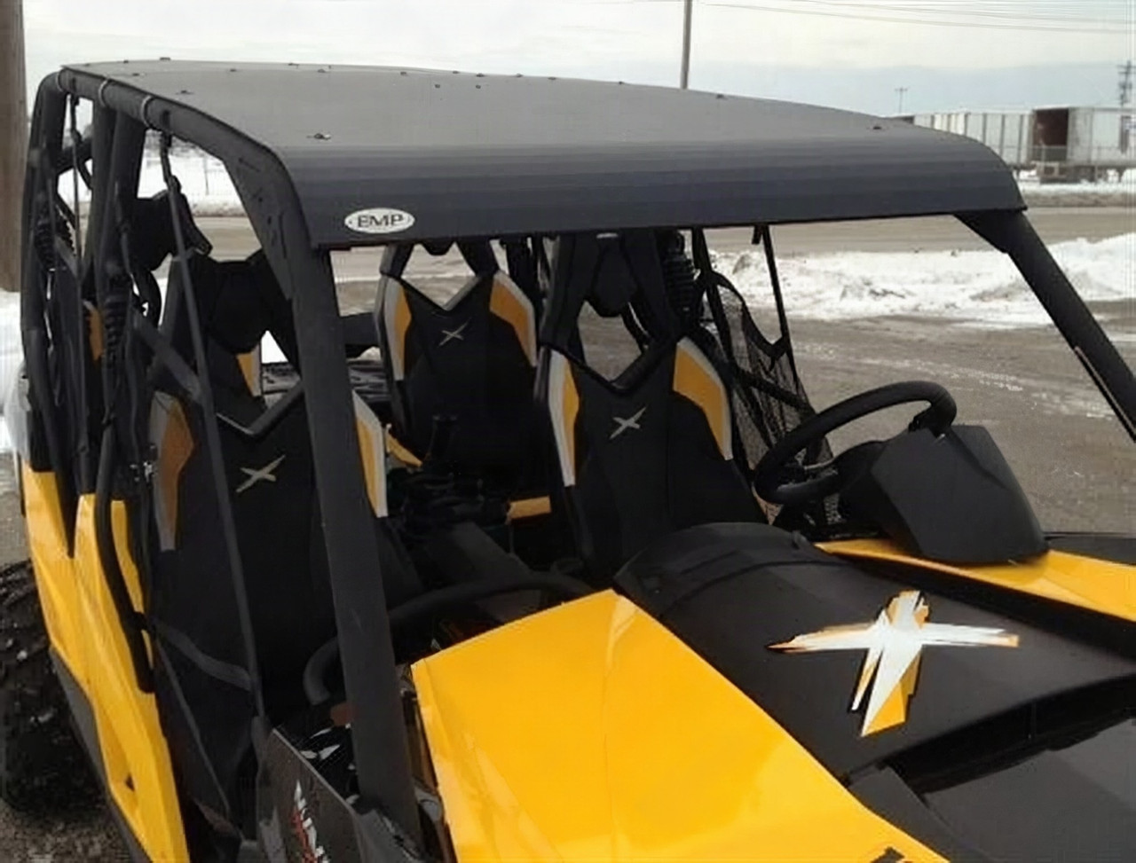 Extreme Metal Products black aluminum top installed on a yellow Can-Am Maverick Max, front angle from above in snow