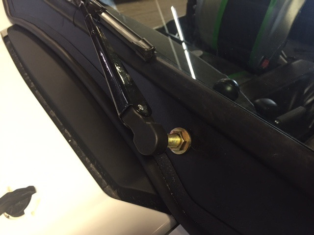 Close-up of the wiper arm pivot and brass nut at the frame corner of the Extreme Metal Products Kawasaki Teryx windshield