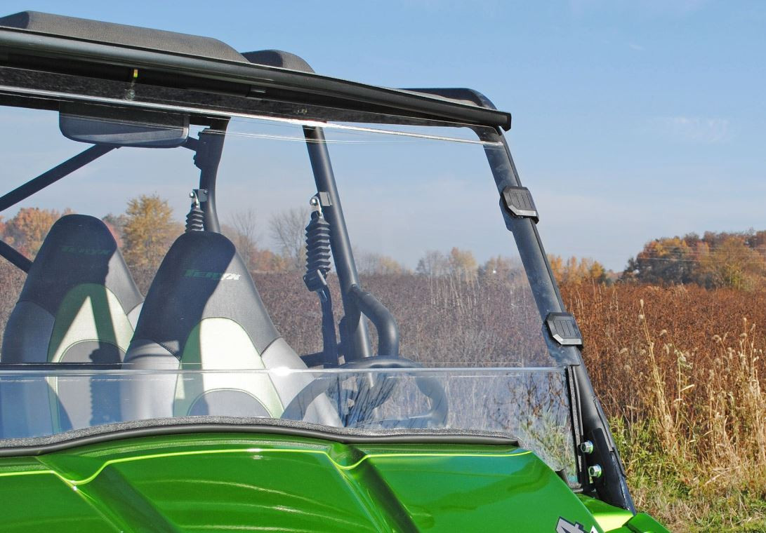 Side view of the SuperATV full windshield and cage clamps on a green Kawasaki Teryx with a roof