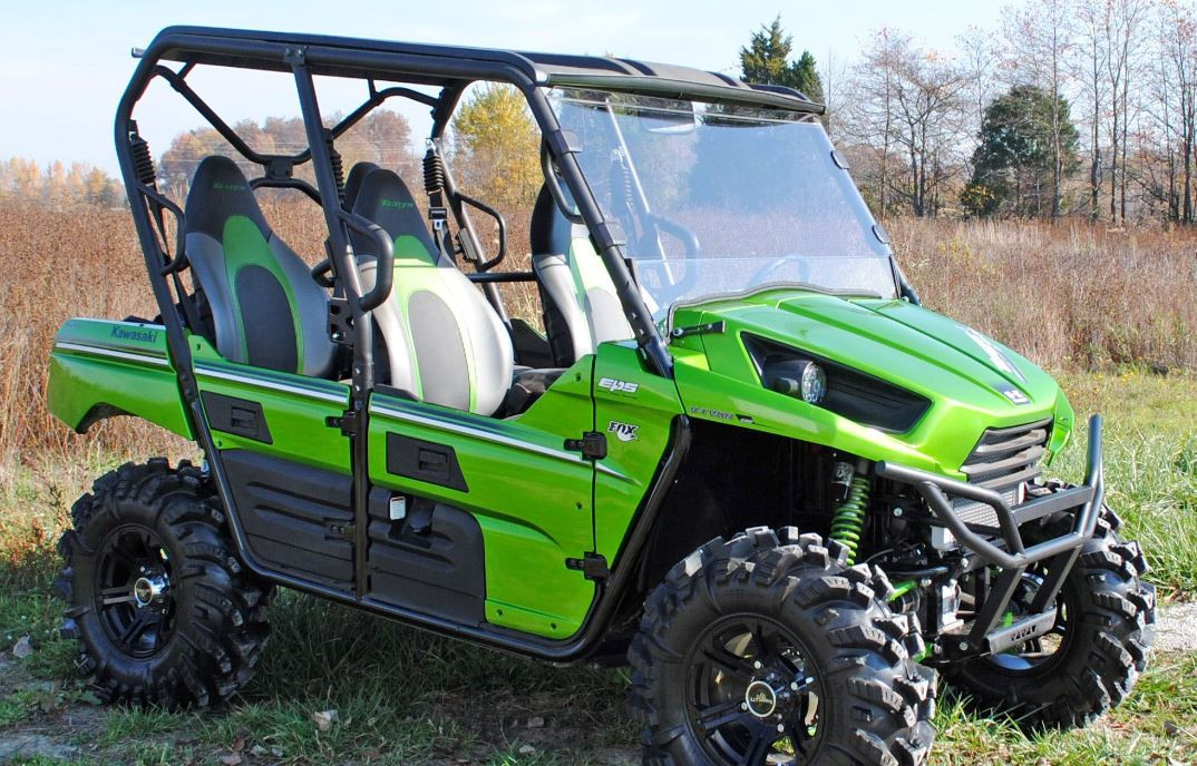 Side profile of a green four-seat Kawasaki Teryx with the SuperATV full windshield and roof installed
