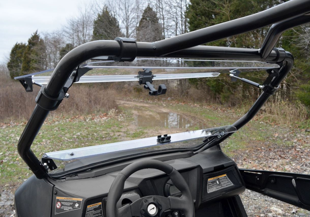 Driver side view from the cab of the SuperATV flip-up windshield open on the Arctic Cat Wildcat Trail, steering wheel below
