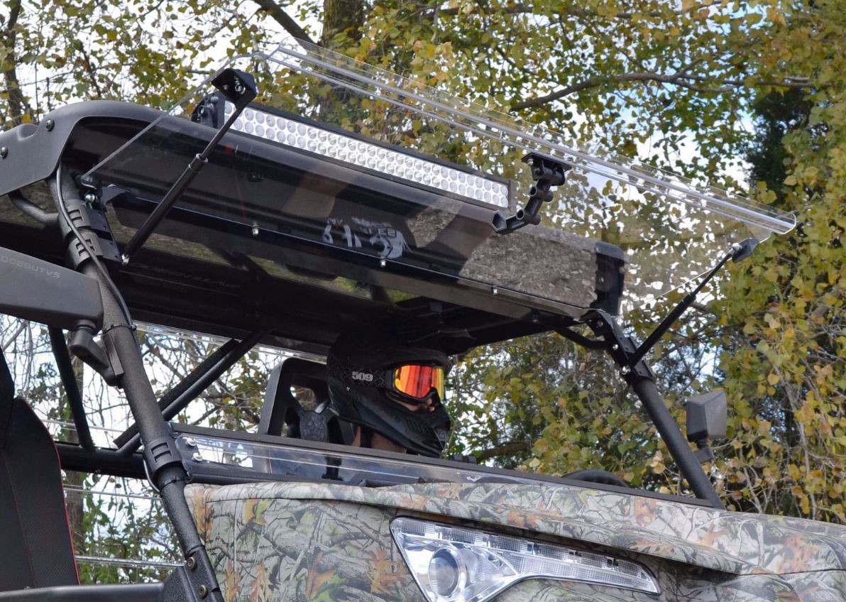 SuperATV flip-up windshield on the Odes Dominator raised to the open position under the roof and light bar