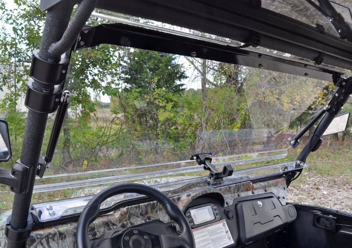 View from the Odes Dominator driver seat through the SuperATV flip-up windshield with the latches visible