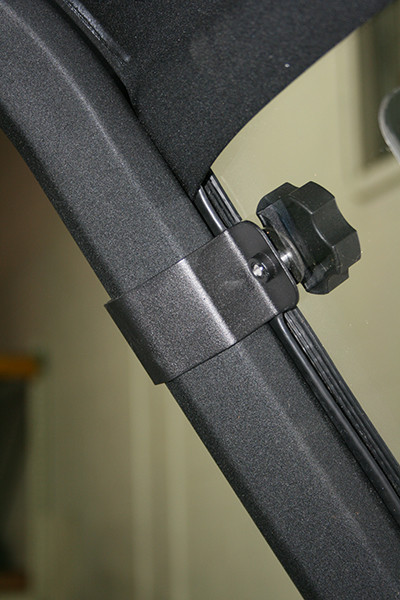 Spike windshield for Can-Am Defender and Defender MAX: close-up of a mounting knob and clamp on the cage tube