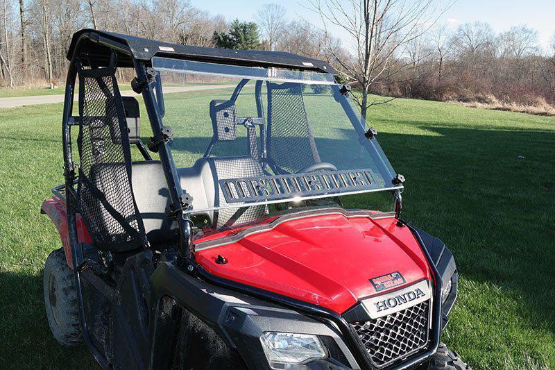 Red Honda Pioneer 500 with the Spike Powersports full venting windshield and roof, front three-quarter view