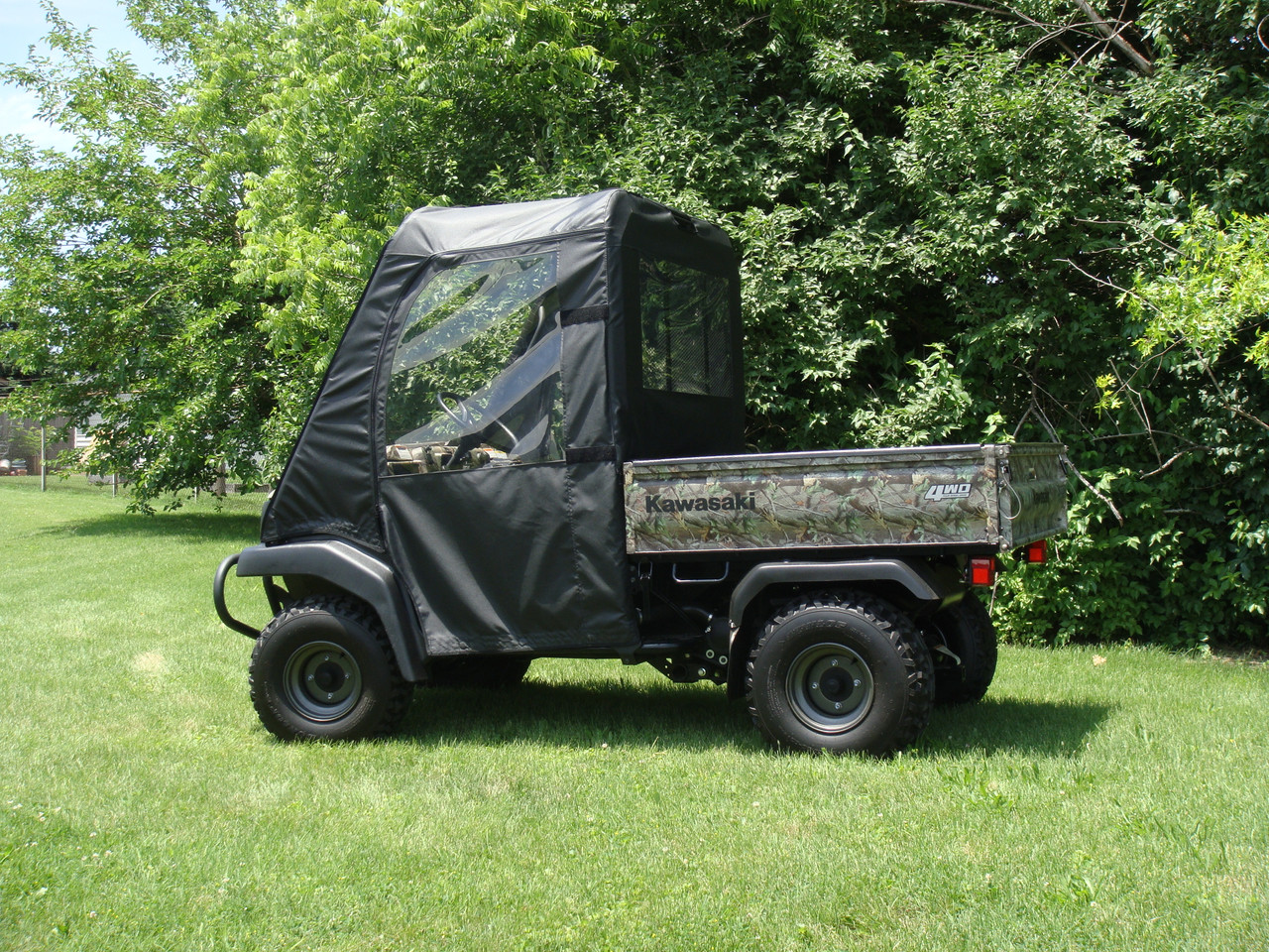 3 Star full cab enclosure with soft doors, top and rear window on a camo Kawasaki Mule 3010, side view on a lawn