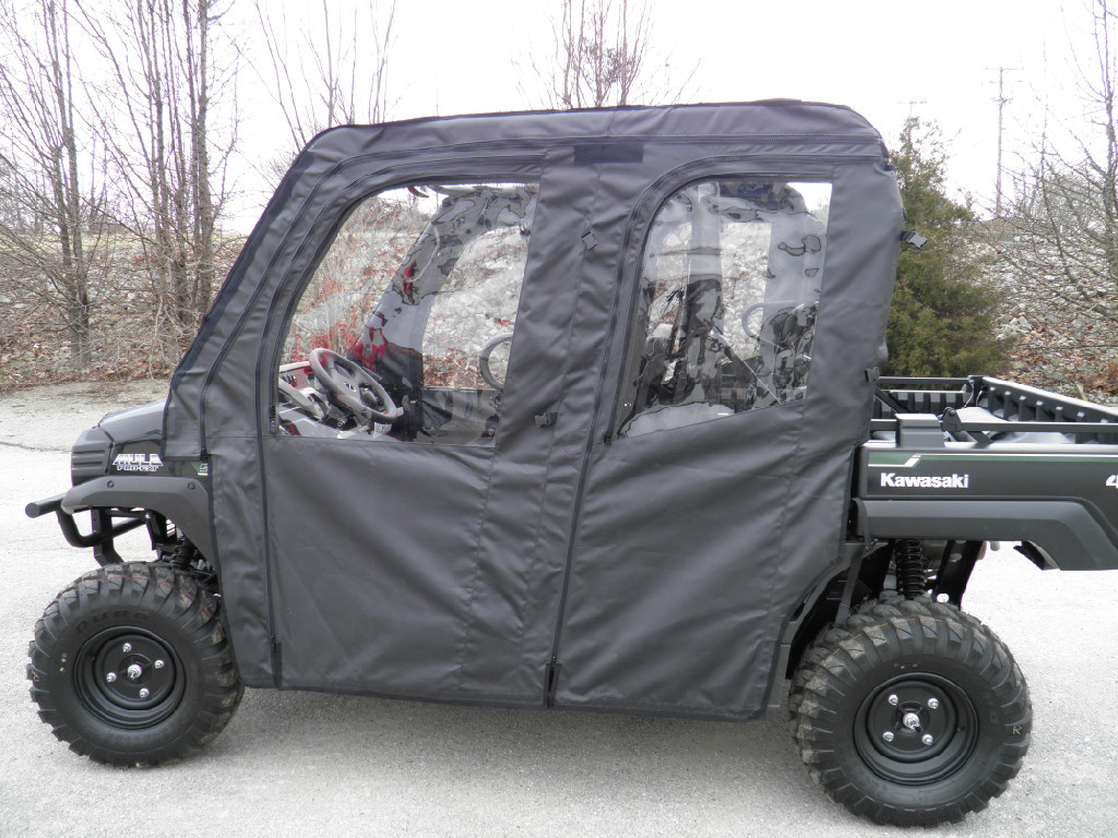 3 Star full cab enclosure with soft doors and clear windows on a black Kawasaki Mule, side view in a parking lot