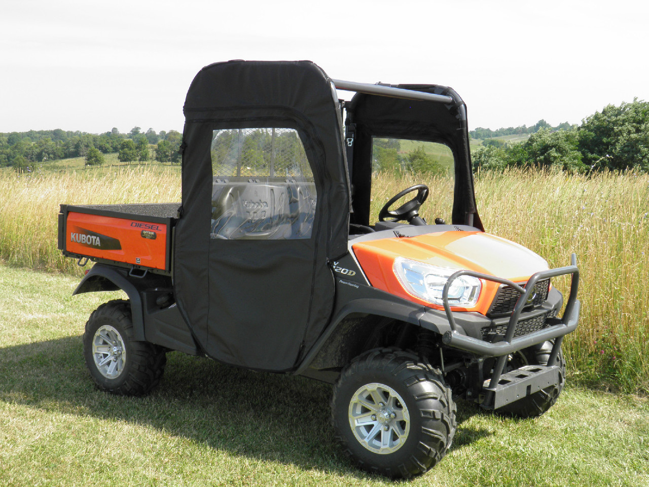 Driver side front angle of the orange Kubota RTV with the 3 Star enclosure door and clear windows