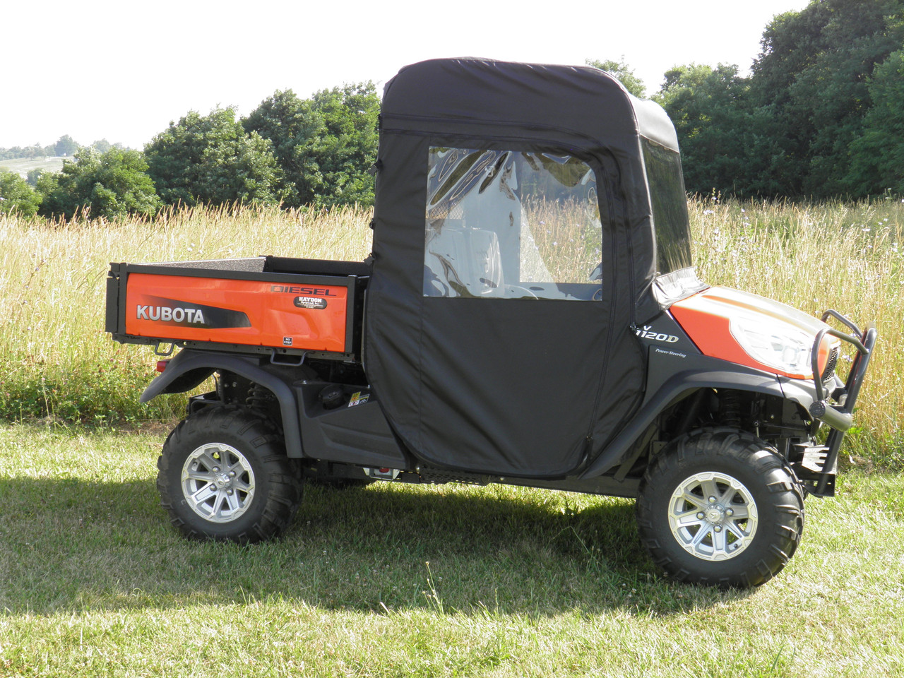 Side view of the orange Kubota RTV X900 with the 3 Star full cab enclosure and clear vinyl door windows