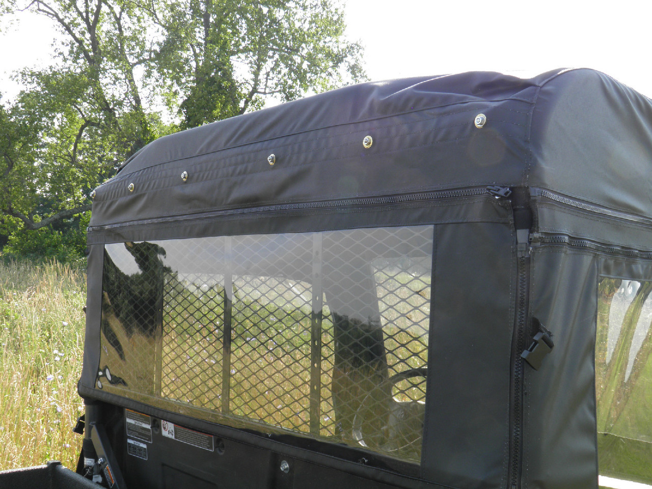 Close-up of the 3 Star cab enclosure rear window panel with snap fasteners and clear vinyl on the Kubota RTV