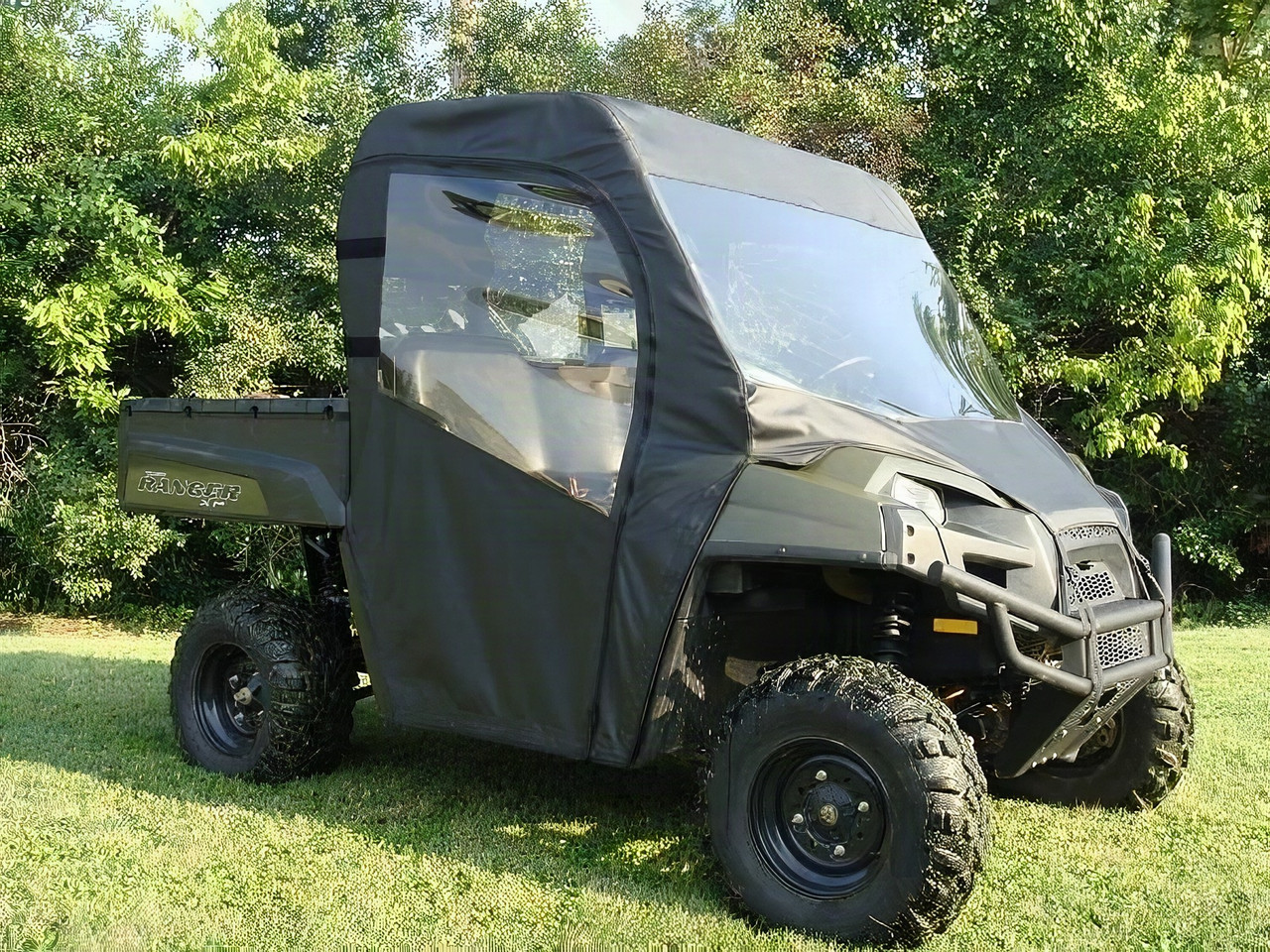3 Star full cab enclosure with vinyl windshield installed on a green Polaris Ranger, front three-quarter view