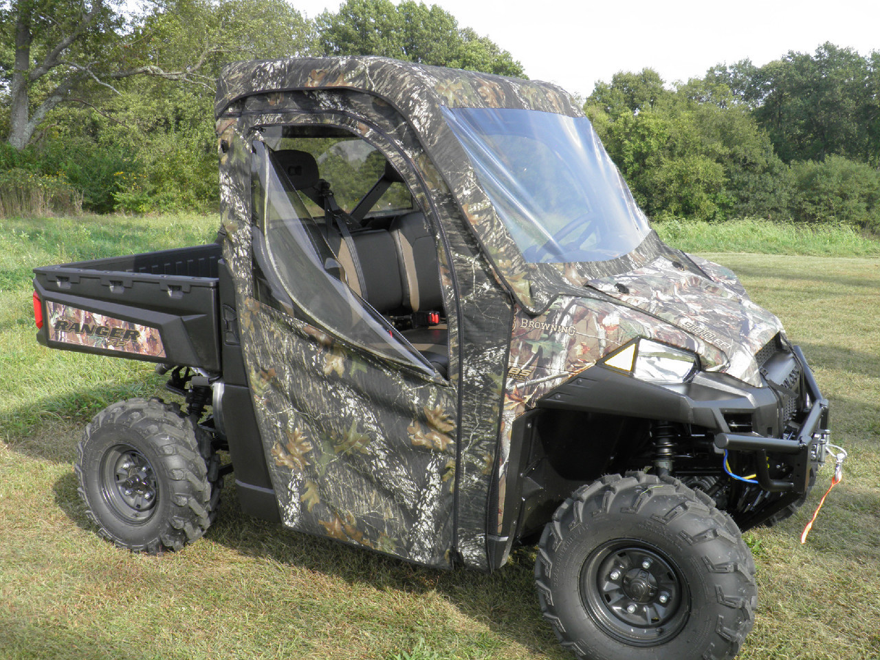Front three-quarter view of a camo Polaris Ranger XP900 with 3 Star full cab enclosure and clear doors