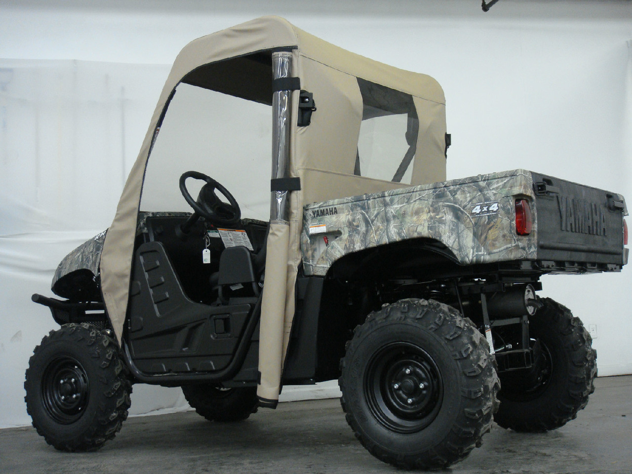 Rear three-quarter view of a Yamaha Rhino with the 3 Star tan cab enclosure door opening unzipped