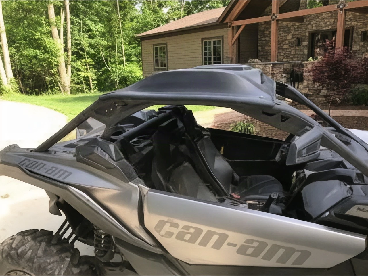 Extreme Metal Products Cooter Brown aluminum roof on a silver Can-Am Maverick X3, side view by a house