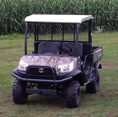 Camo Kubota RTV with the Wiedmann Bros diamond plate aluminum roof, front three-quarter view on grass