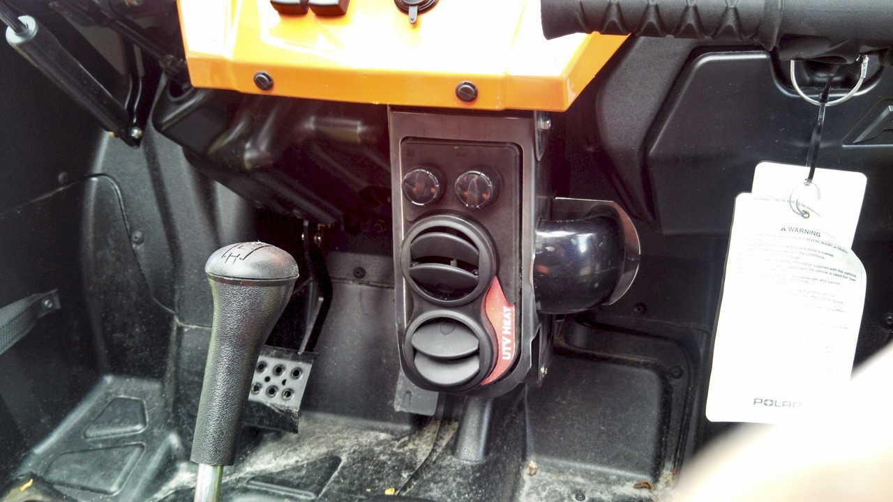Lower angle of the Ice Crusher heater unit and vents under the RZR dash with the shift lever and floorboard in view
